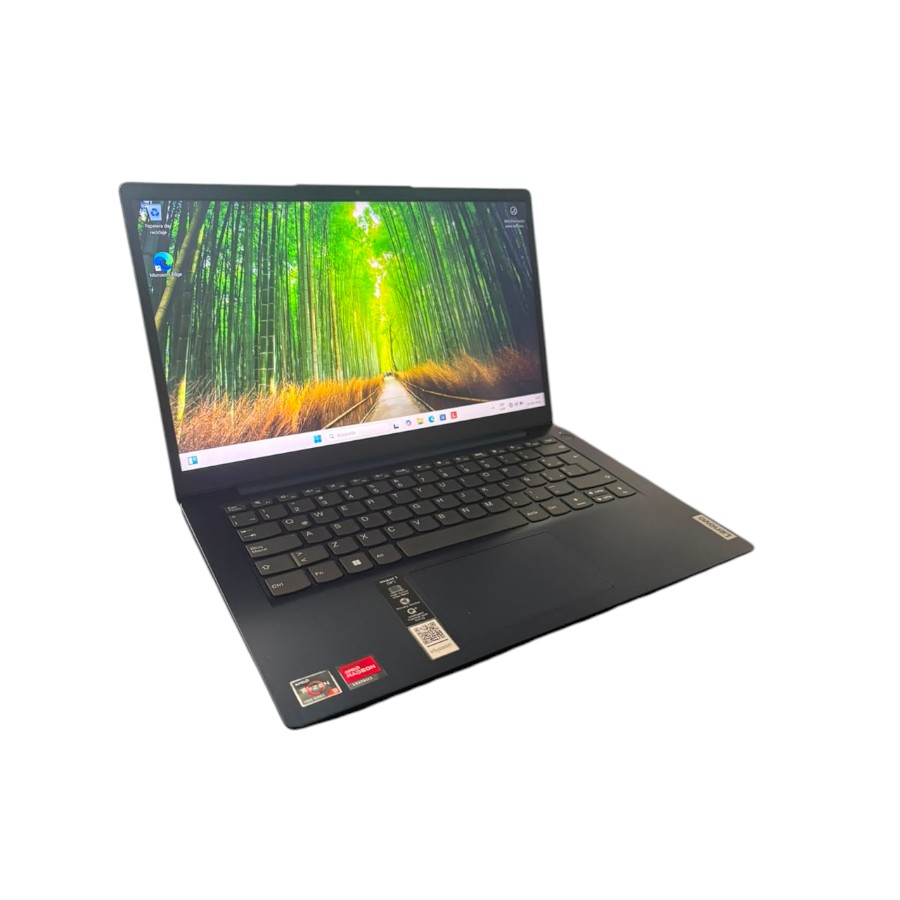 Laptop Lenovo IdeaPad 3 abierta en ángulo diagonal izquierdo, mostrando la pantalla encendida con un fondo de pantalla de un bosque de bambú verde brillante.